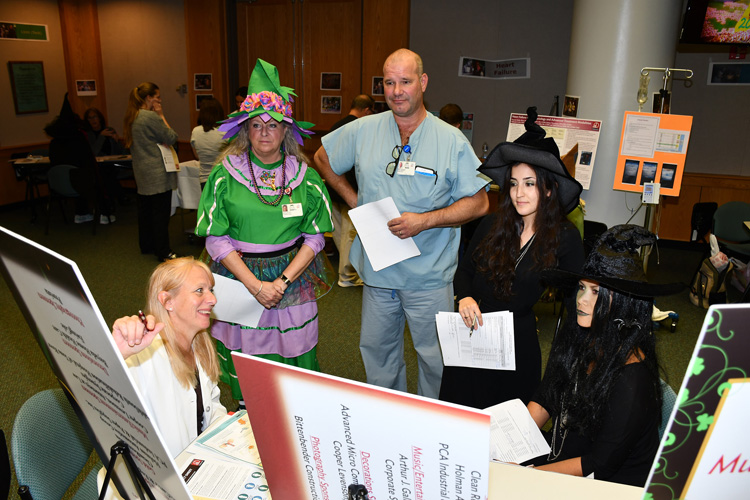 Group of nurses, some dressed in Halloween costumes, listening to information for continuing medical education.