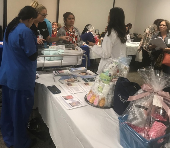 Hackensack Meridian Health Raritan Bay Medical Center staff hosting annual baby fest with brochures and baby items.