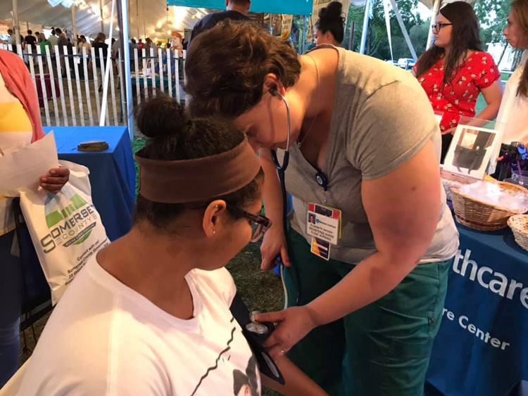 Hunterdon Healthcare doctor providing a blood pressure check at Somerset County 4H Fair.