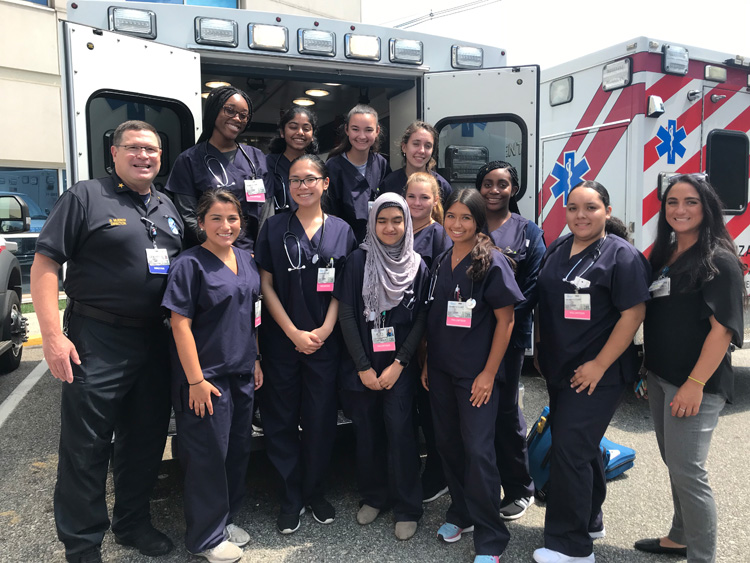 Rod Muench posing with a group of trainee nurses in the back of an ambulance.