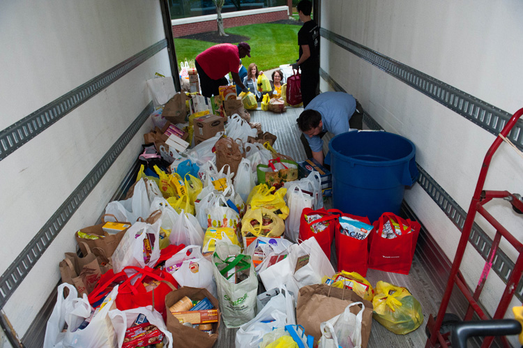 Virtua Health staff stocking bags of food in a truck.