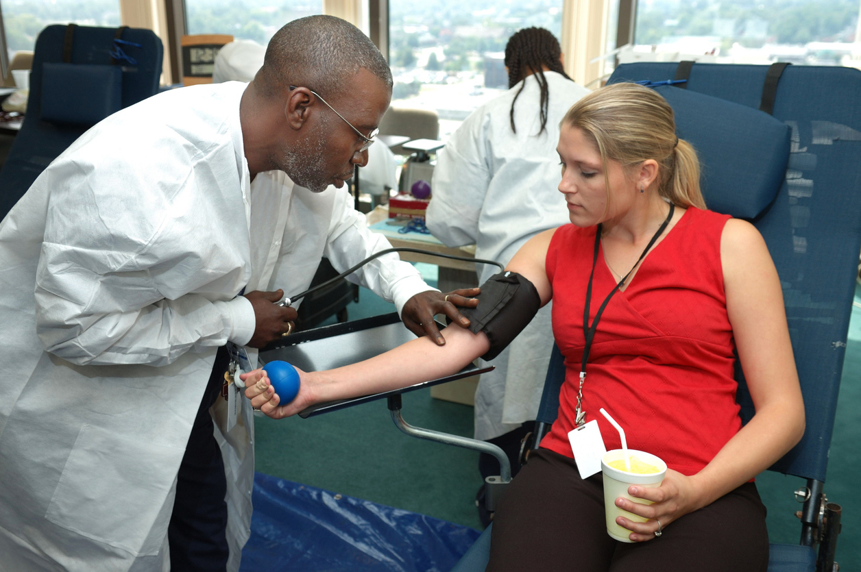 Male doctor drawing blood from female patient.