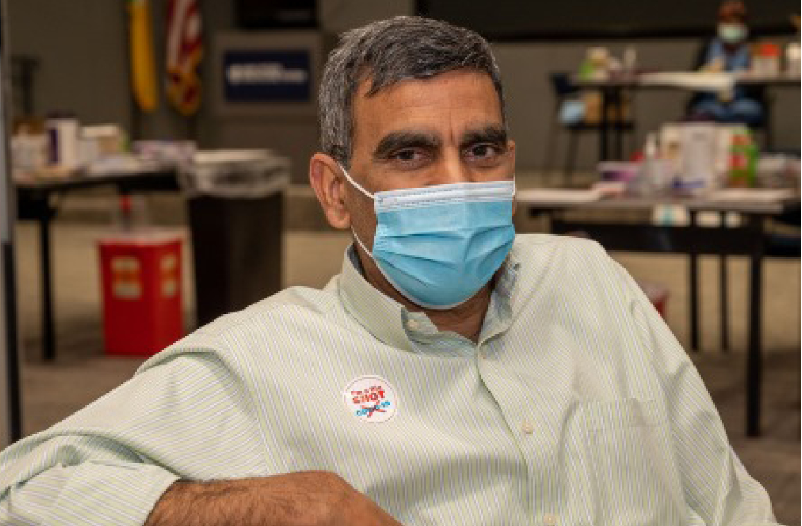 Male healthcare worker wearing a I'm a Big Shot sticker.